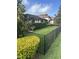 Well-manicured backyard featuring lush green grass, privacy hedges, and a secure black metal fence at 4622 Grand Lakeside Dr, Palm Harbor, FL 34684