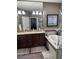 Bathroom featuring double vanity sinks, a soaking tub, and a glass-enclosed shower, perfect for relaxation at 4622 Grand Lakeside Dr, Palm Harbor, FL 34684
