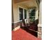 Inviting front porch with decorative stone accents and cozy rocking chairs on a patterned brick floor at 4622 Grand Lakeside Dr, Palm Harbor, FL 34684