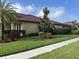 Well-maintained lawn features lush landscaping, mature trees, and a tidy garden bed at 4622 Grand Lakeside Dr, Palm Harbor, FL 34684