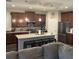 Spacious kitchen featuring dark cabinets, stainless steel appliances, and a center island with bar seating at 4622 Grand Lakeside Dr, Palm Harbor, FL 34684