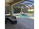Stylish screened-in patio with comfortable seating, overlooking the pool and spa for ultimate relaxation at 4622 Grand Lakeside Dr, Palm Harbor, FL 34684