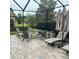 Covered screened patio features a fire pit, comfortable seating, and outdoor living space at 4622 Grand Lakeside Dr, Palm Harbor, FL 34684