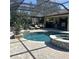 Relaxing screened pool includes spa, lounge chairs, and a covered outdoor seating area at 4622 Grand Lakeside Dr, Palm Harbor, FL 34684