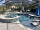 Beautiful screened pool features a built-in spa, chaise lounges, and lush landscaping at 4622 Grand Lakeside Dr, Palm Harbor, FL 34684
