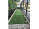 Backyard putting green with artificial turf and decorative stone border, great for golf enthusiasts at 4622 Grand Lakeside Dr, Palm Harbor, FL 34684