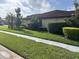 Street view of a house showing the sidewalk, lawn, and landscaping, under a cloudy sky at 4622 Grand Lakeside Dr, Palm Harbor, FL 34684