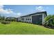A beautifully landscaped backyard featuring a screened lanai, manicured lawn, and a screened pool enclosure at 4725 Antrim Dr, Sarasota, FL 34240