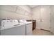 Functional laundry room with modern appliances, storage shelving, and convenient access to laundry facilities at 4725 Antrim Dr, Sarasota, FL 34240