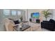 Inviting living room with large windows, plush seating, and a modern entertainment center for relaxing and entertaining at 4725 Antrim Dr, Sarasota, FL 34240