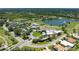 Aerial view of a golf club, community pool, tennis court, and surrounding golf course under a blue sky at 5320 Hyland Hills Ave # 2214, Sarasota, FL 34241