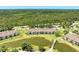 An aerial view of condo community with bridge over pond and pool area surrounded by lush trees on a sunny day at 5320 Hyland Hills Ave # 2214, Sarasota, FL 34241