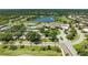 Aerial view of a golf club, community pool, and parking lot surrounded by lush greenery and a golf course at 5320 Hyland Hills Ave # 2214, Sarasota, FL 34241