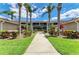 Beautifully landscaped condo building with lush greenery and a welcoming pathway at 5320 Hyland Hills Ave # 2214, Sarasota, FL 34241