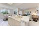 Open kitchen design with white cabinets and countertops overlooking a dining area with a view of the outside at 5320 Hyland Hills Ave # 2214, Sarasota, FL 34241