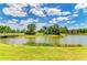 Scenic lake view framed by lush landscaping and a beautiful community, perfect for relaxing or enjoying the outdoors at 5320 Hyland Hills Ave # 2214, Sarasota, FL 34241