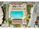 Aerial view of a community pool with a jacuzzi, lounge chairs, umbrellas, and a paved deck at 5320 Hyland Hills Ave # 2214, Sarasota, FL 34241