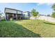 Spacious backyard featuring a covered patio, well-maintained lawn, and white vinyl fence, perfect for outdoor enjoyment at 5426 Rainwood Meadows Dr, Apollo Beach, FL 33572