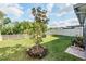 Expansive backyard with a young tree, lush green grass, a brick paver, and a white privacy fence at 5426 Rainwood Meadows Dr, Apollo Beach, FL 33572