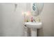 Bathroom boasts a pedestal sink, an oval mirror, and neutral wall color to create a serene, minimalist space at 5426 Rainwood Meadows Dr, Apollo Beach, FL 33572
