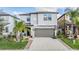 Inviting two-story home featuring a manicured lawn, a basketball hoop, and a convenient two-car garage at 5426 Rainwood Meadows Dr, Apollo Beach, FL 33572