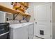 Laundry room offers a full-size washer and dryer, floating shelves, and a pet door for ultimate convenience at 5426 Rainwood Meadows Dr, Apollo Beach, FL 33572