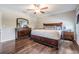 Main bedroom featuring dark wood floors, a ceiling fan, and bedside tables on either side of the bed at 5426 Rainwood Meadows Dr, Apollo Beach, FL 33572
