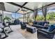Inviting enclosed patio with comfortable wicker furniture, an outdoor grill, and serene views for entertaining at 5426 Rainwood Meadows Dr, Apollo Beach, FL 33572