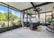 Enclosed patio featuring a cozy wicker furniture set with blue cushions and beautiful outdoor views at 5426 Rainwood Meadows Dr, Apollo Beach, FL 33572