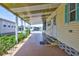 Covered patio entrance featuring a well-maintained pathway, complemented by adjacent greenery and nearby homes at 5619 Bayshore Rd # 211, Palmetto, FL 34221