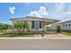 Charming single-story home featuring a covered carport, landscaped front yard, and inviting entryway with palm trees at 5619 Bayshore Rd # 211, Palmetto, FL 34221