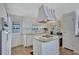 Functional kitchen featuring a central island with cooktop, classic white appliances, and convenient access to the outside at 5619 Bayshore Rd # 211, Palmetto, FL 34221