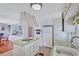 Kitchen with a cooktop island, white appliances, and open layout leading into the dining and living spaces at 5619 Bayshore Rd # 211, Palmetto, FL 34221
