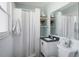 Bright bathroom with white tile and a shower with curtain at 5675 Saint Louis Ave, Sarasota, FL 34233
