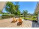 Inviting wooden deck with Adirondack chairs overlooking serene water and lush landscaping at 5675 Saint Louis Ave, Sarasota, FL 34233
