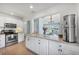 This kitchen features white cabinets and stainless steel appliances at 5675 Saint Louis Ave, Sarasota, FL 34233