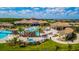 Aerial view of the community clubhouse and pool featuring rock waterfalls and tropical palms at 5694 Palmer Cir # 202, Bradenton, FL 34211