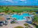 Aerial view of community pool and clubhouse with outdoor seating and tropical landscaping at 5694 Palmer Cir # 202, Bradenton, FL 34211