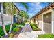 Condo exterior with a beautiful brick walkway, lush shrubs and palm trees at 5694 Palmer Cir # 202, Bradenton, FL 34211