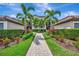 Beautifully landscaped condo building featuring mature palms and a brick walkway at 5694 Palmer Cir # 202, Bradenton, FL 34211