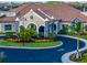Striking exterior view of luxury community clubhouse with decorative circular driveway and landscaping at 5694 Palmer Cir # 202, Bradenton, FL 34211