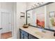 Modern bathroom with decorative mirror, gray vanity, and shower with a curtain at 6311 Sturbridge Ct, Sarasota, FL 34238