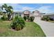 Inviting single-Gathering home with lush greenery, a paved driveway, and a two-car garage at 6311 Sturbridge Ct, Sarasota, FL 34238