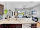 Open-concept kitchen showcasing a breakfast bar and views of the living area and outdoor lanai at 6311 Sturbridge Ct, Sarasota, FL 34238