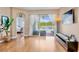 Open-plan living area with hardwood floors and sliding glass doors overlooking water and pool at 6311 Sturbridge Ct, Sarasota, FL 34238