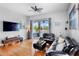Spacious living room features wood floors, a ceiling fan, and sliding doors to the screened lanai at 6311 Sturbridge Ct, Sarasota, FL 34238