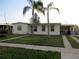 Modest single-story home featuring a well-kept lawn and two palm trees in front at 6339 Pontiac Ln, North Port, FL 34287