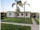 Charming single-story home with a well-maintained lawn and mature palm trees in the front yard at 6339 Pontiac Ln, North Port, FL 34287