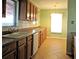 Galley kitchen featuring wood cabinets, tile floors and double basin sink at 6339 Pontiac Ln, North Port, FL 34287