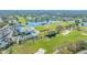 Aerial view showcases the golf course with the clubhouse, parking, a pond, greens, and residential community in the background at 6501 Stone River Rd # 304, Bradenton, FL 34203